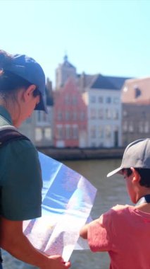 Bir kadın ve küçük oğlu şehirde bir haritayı inceliyor..