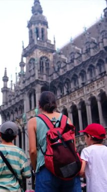 Sırt çantası ve küçük oğulları olan bir kadın şehrin tarihi mimarisine hayran..