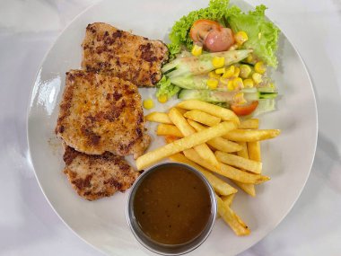Izgara tavuk, patates kızartması, taze salata ve sos, sıradan batı yemeği konsepti.