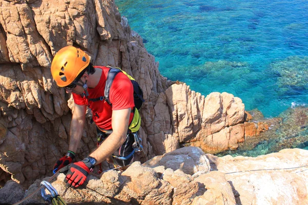 Mann arbeitet in einem Klettersteig über dem Meer — Stockfoto