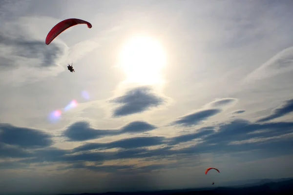 Paracaídas volando alto con el sol —  Fotos de Stock