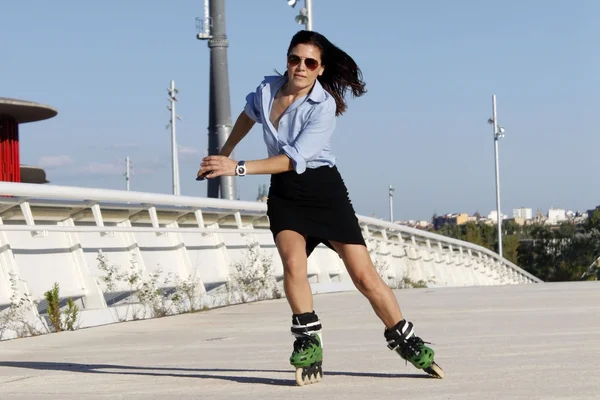 Mujer patinadora exceso de velocidad a la derecha con una falda — Foto de Stock