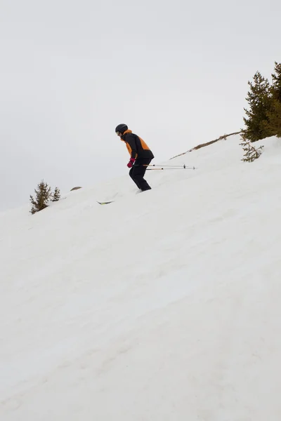 Лыжник спускается с холма — стоковое фото