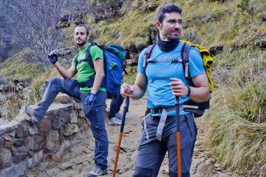 Dağlarda yürüyüş yapan iki adam.