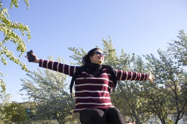 Mujer muy feliz en un parque escuchando música — Foto de Stock