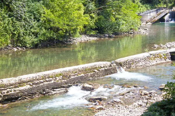 Cascades dans un lac au bord d'une rivière avec des pierres en été — Photo