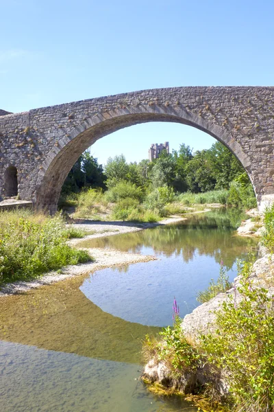 Brug in Lagrasse met de abdij achter en de reflectie in de rivier — Stockfoto