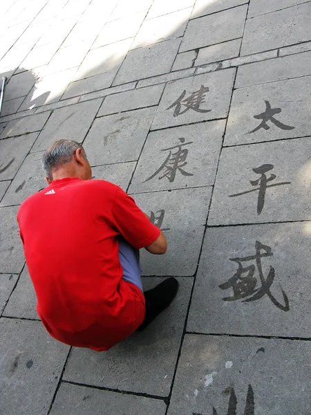 Street art. Ephemeral Chinese ideograms painted with water — Stock Photo, Image
