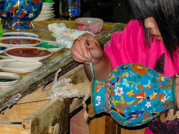 Kadın el bir porselen vazo bir damlalık ile dekore edilmiştir.