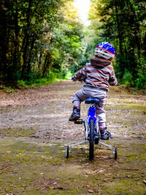 çocuk ormanda bir bisiklet sürme