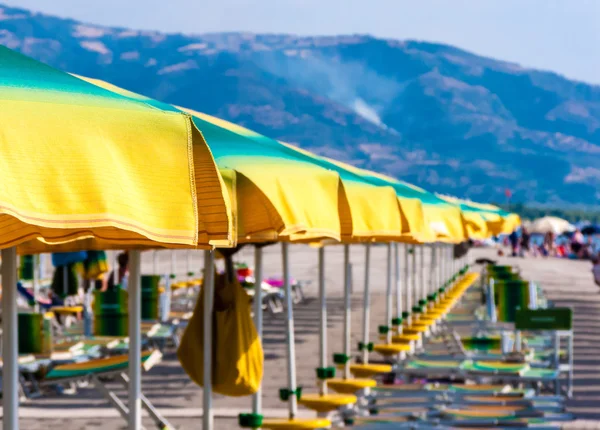 Satır bir Akdeniz sahil üzerinde renkli şemsiye. İyonya Denizi, 