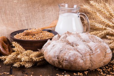 Ahşap masa arkasında pişmiş ekmek çeşitleri