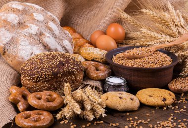 Ahşap masa arkasında pişmiş ekmek çeşitleri