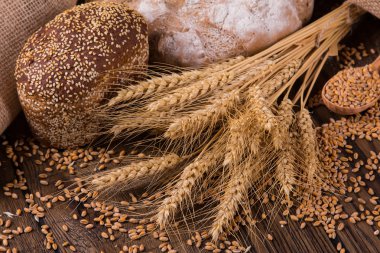 Ahşap masa arkasında pişmiş ekmek çeşitleri