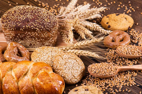 Auswahl an gebackenem Brot auf Holztischhintergrund — Stockfoto