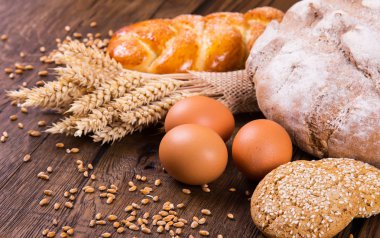 Ahşap masa arkasında pişmiş ekmek çeşitleri