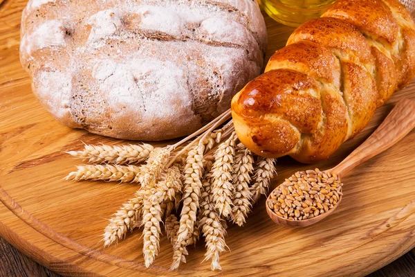 Auswahl an gebackenem Brot auf Holztischhintergrund — Stockfoto