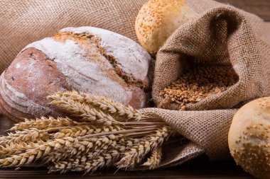 Ahşap masa arkasında pişmiş ekmek çeşitleri