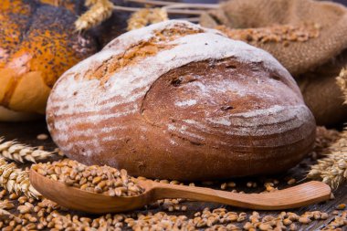 Ahşap masa arkasında pişmiş ekmek çeşitleri