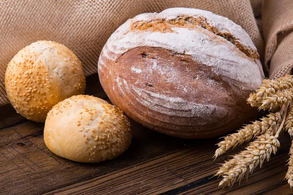 Sortimento de pão assado em fundo de mesa de madeira — Fotografia de Stock