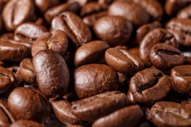 Taze kavrulmuş kahve çekirdekleri. Ahşap arka planda kepçeyle kavrulmuş kahve çekirdekleri..