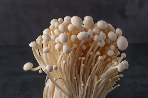 Taze Enoki mantarları seçilmiş odaklı olarak siyah zemin üzerinde bulunur. Enoki, ayrıca kadife şiş olarak da bilinir, Physalacriaceae familyasından yenilebilir bir mantar türüdür.. 