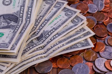 Amerikan paraları ve Amerikan doları ahşap bir masada.