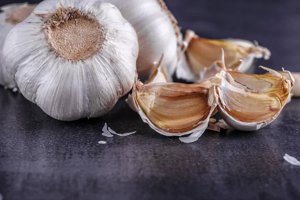 Knoblauch Und Knoblauchknollen Auf Einem Schwarzen Teller — Stockfoto