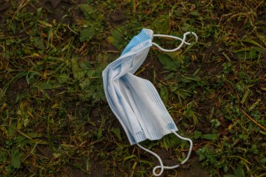 Sokakta yerde tıbbi maske var. Çevre kirliliği kavramı. COVID-19 sırasındaki israf. Coronavirüsü önle.  