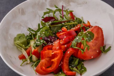 Vegan Bahar Salatası. Domates, marul, sos, dolmalık biber ve avokado. Sebzeli çatal ve salata..