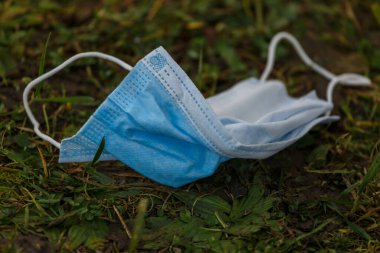 Sokakta yerde tıbbi maske var. Çevre kirliliği kavramı. COVID-19 sırasındaki israf. Coronavirüsü önle.  