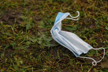 Sokakta yerde tıbbi maske var. Çevre kirliliği kavramı. COVID-19 sırasındaki israf. Coronavirüsü önle.  