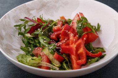 Vegan Bahar Salatası. Domates, marul, sos, dolmalık biber ve avokado. Sebzeli çatal ve salata..