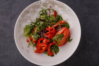 Vegan Bahar Salatası. Domates, marul, sos, dolmalık biber ve avokado. Sebzeli çatal ve salata..