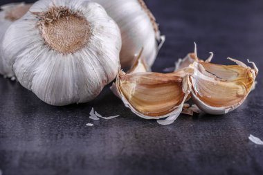 Sarımsak ve sarımsak soğanı siyah tabakta.