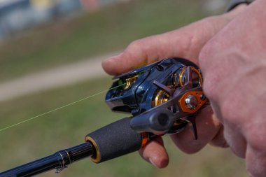 Akşam gölü üzerinde dönen ve makaralı bir el. Gün batımında gölde balık tutmak. Balıklama arkaplanı.