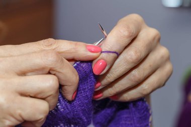  Yün ipliği kullanarak el yapımı giysiler ören bir kadının elleri. Boş zaman etkinliği kavramı. İplikten örgü örmek..