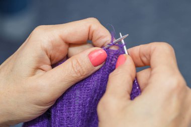  Yün ipliği kullanarak el yapımı giysiler ören bir kadının elleri. Boş zaman etkinliği kavramı. İplikten örgü örmek..