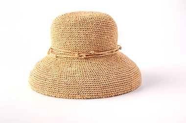 Güzel bir hasır şapka, güzel bir kurdele ve kumsal şapkası, beyaz arka plan. Moda kıyafetleri aksesuarları ve plaj tatilleri kavramı. Karışık rafya liflerinden yapılmış yaz hasır şapka dokusu yakın plan.
