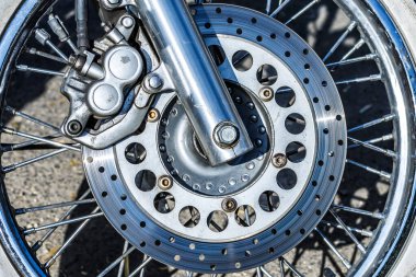 Park etmiş özel bir motosikletin ön lastiği. Motosiklet motoru yakın çekim. Krom motor parçaları. Pürüzsüz detaylar.
