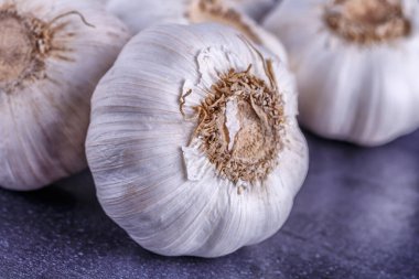 Sarımsak ve sarımsak soğanı siyah bir masada.