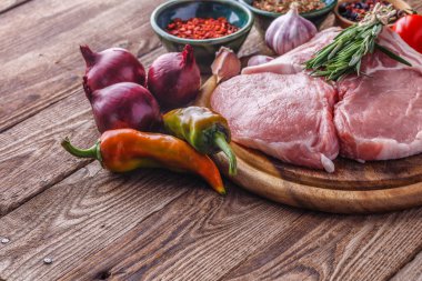 Tahta tahtada taze çiğ New York bifteği ahşap arka planda tuz ve biberli, köy usulü..