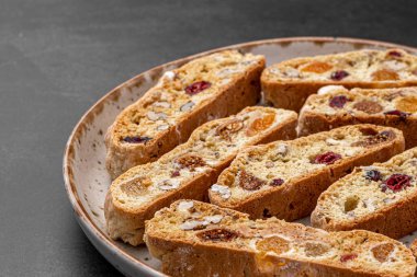 İtalyan bademli bisküvileri kırsal bir evde yapılmış çömlek kasesinde. Badem ve yaban mersiniyle süslenmiş bu iki kez pişirilmiş ikramlar aromatik ve davetkar. İdeal.