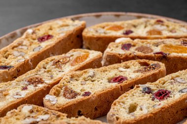 İtalyan bademli bisküvileri kırsal bir evde yapılmış çömlek kasesinde. Badem ve yaban mersiniyle süslenmiş bu iki kez pişirilmiş ikramlar aromatik ve davetkar. İdeal.