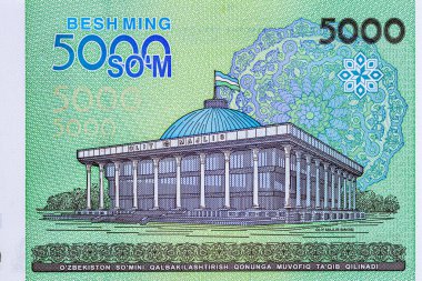 5000 Özbek banknotu. Ters tarafta Taşkent 'teki parlamento binası, ters tarafta ise Özbekistan Cumhuriyeti' nin ulusal amblemi yer alıyor..