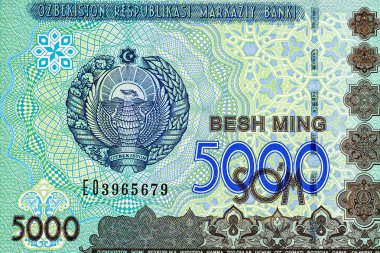 5000 Özbek banknotu. Ters tarafta Taşkent 'teki parlamento binası, ters tarafta ise Özbekistan Cumhuriyeti' nin ulusal amblemi yer alıyor..