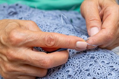 Yün ipliği kullanarak telli el yapımı giysiler ören tanınmamış bir kadının ellerine yakın durun. Boş zaman etkinliği kavramı. İplikten örgü örmek..