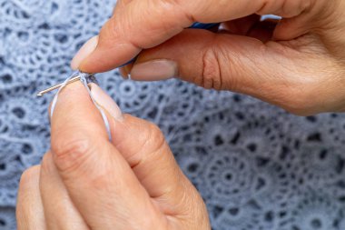 Yün ipliği kullanarak telli el yapımı giysiler ören tanınmamış bir kadının ellerine yakın durun. Boş zaman etkinliği kavramı. İplikten örgü örmek..