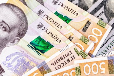 Background with Ukrainian money and American dollars.American dollars and Ukrainian hryvnias. Concept of American aid to Ukraine in the war. Concept of the exchange rate.