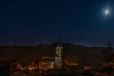 Kasaba koyu renk sonbahar gecesinde tepenin üstünde kiliseyle